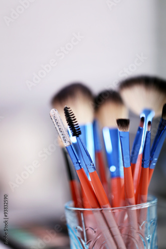 Cosmetic brushes in glass on bright background