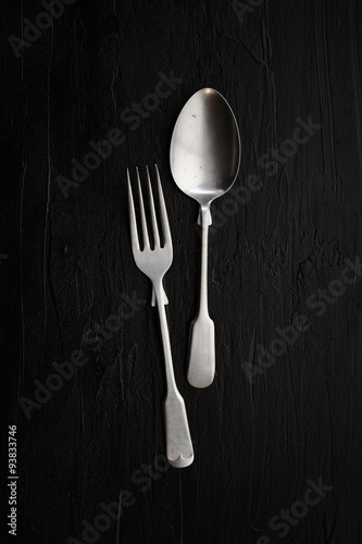 Still life photography with spoon and fork on rustic background,