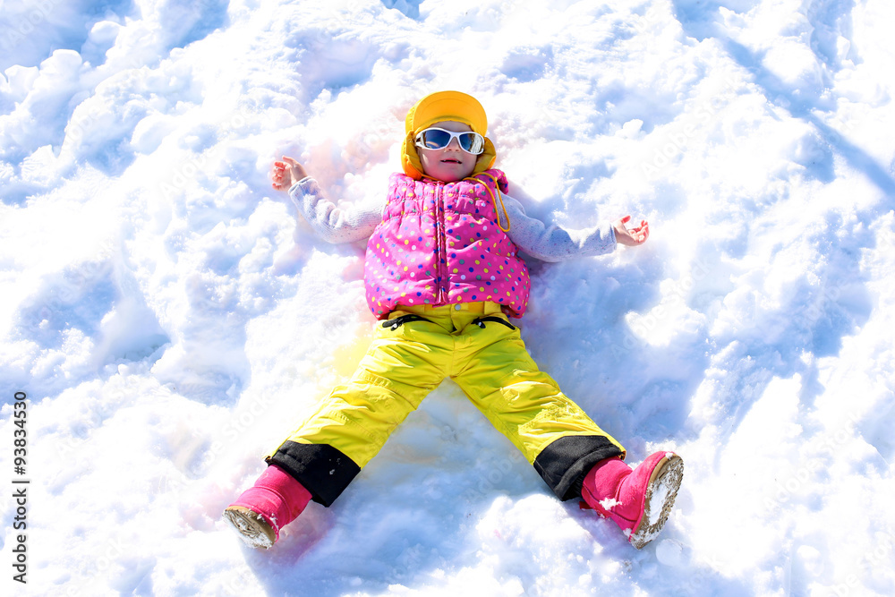 Happy child enjoying winter holidays in Alpine resort in Austria. Little girl playing in the snow. Active sportive toddler learning to ski. Kids having fun outdoors.