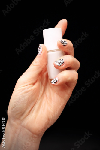 Szalony manicure, czarno biała kratka. Dłoń kobiety z paznokciami pomalowanymi w czarno biała kratkę
