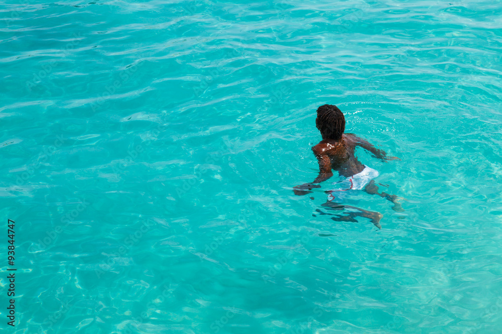 Teenage Cape verdean boy swimming on the turquoise  water of San