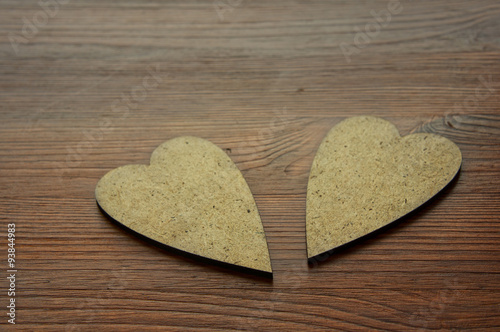 Two wooden hearts on brown background