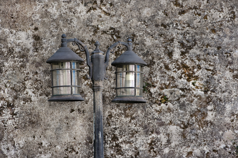 old fashioned street light on the textured wall background old fashioned street light on the textured wall background
