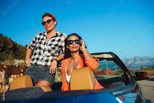 Two young girls having fun in the cabriolet outdoors © vladstar