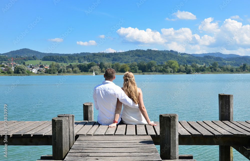 A couple on the wooden jetty at the lake. Switzerland