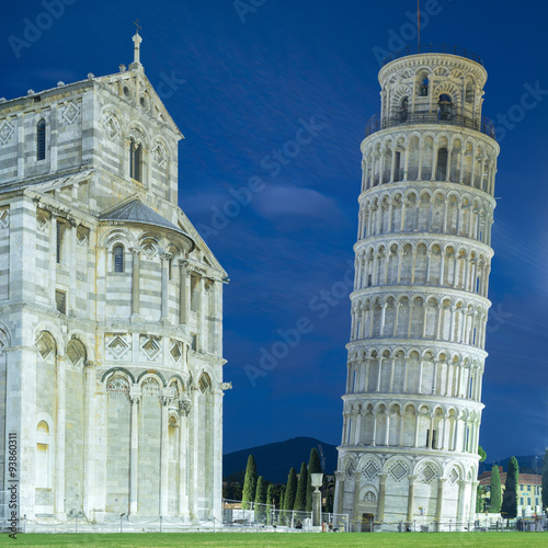 Fotografiet front of cathedral and falling tower in twilight light in Pisa in Italy