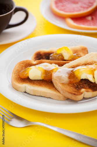 French toast with sliced orange on yellow tablecloth