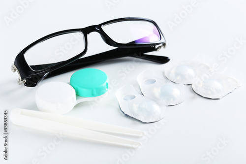 Contact lenses in container with solution on white background