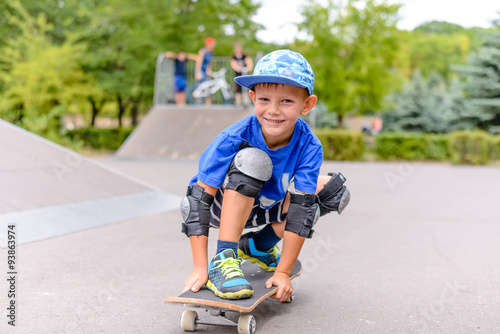 Small boy on his skateboard grinning at the camera
