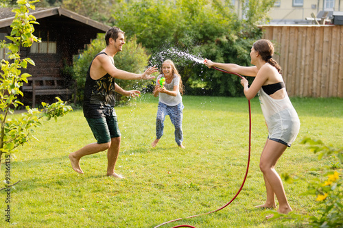 junge Familie spielt mit Wasser