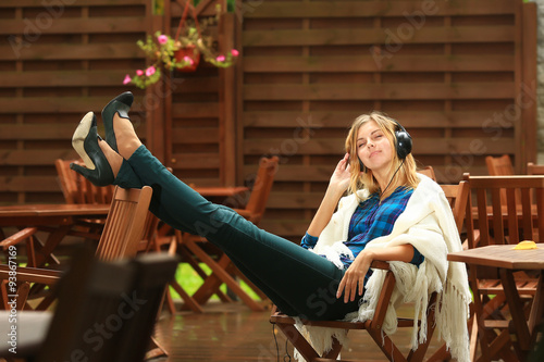 Studenka girl with long legs listening to music on headphones photo