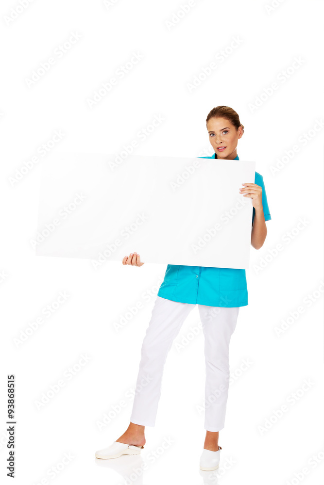 Young female doctor or nurse holding empty banner Young female doctor or nurse holding empty banner