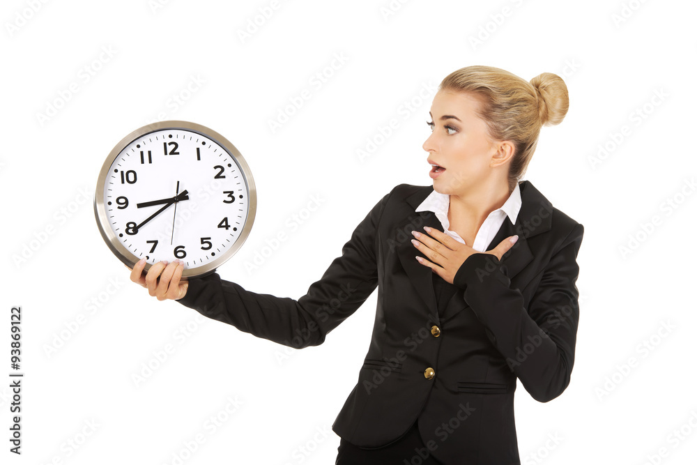 Young businesswoman terrified looks at the clock Young businesswoman terrified looks at the clock