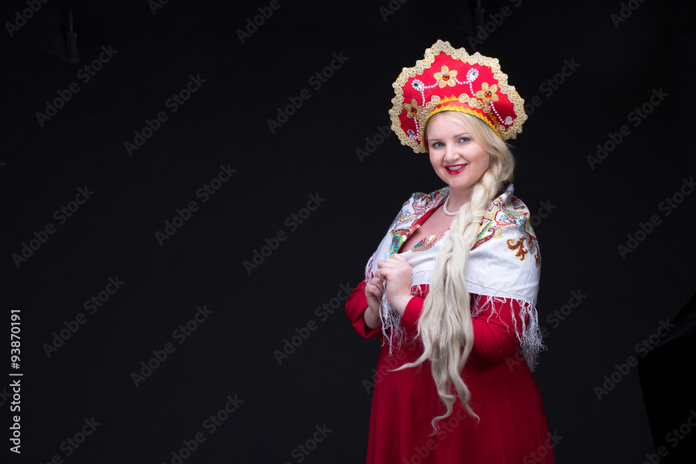 Girl standing in Russian traditional costume. Woman is wearing s
