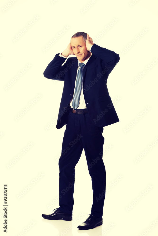 Tired man covering ears with hands Tired man covering ears with hands