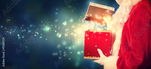 Santa Claus opening a red Christmas present