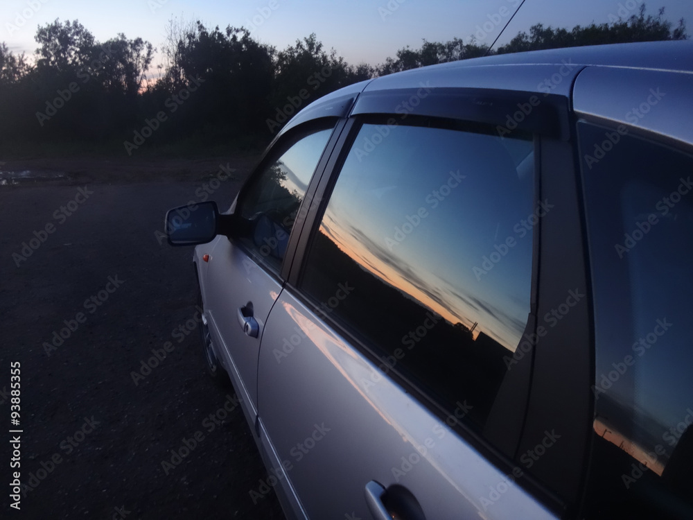 Закат, отражающийся в стеклах автомобиля
