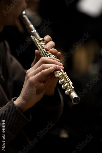 Hands of musician playing a flute in dark colors