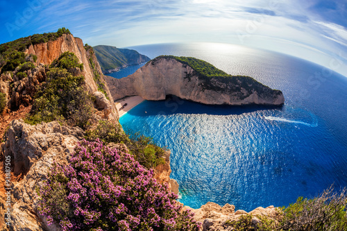 Navagio beach with shipwreck and flowers against sunset, Zakynthos island, Greece