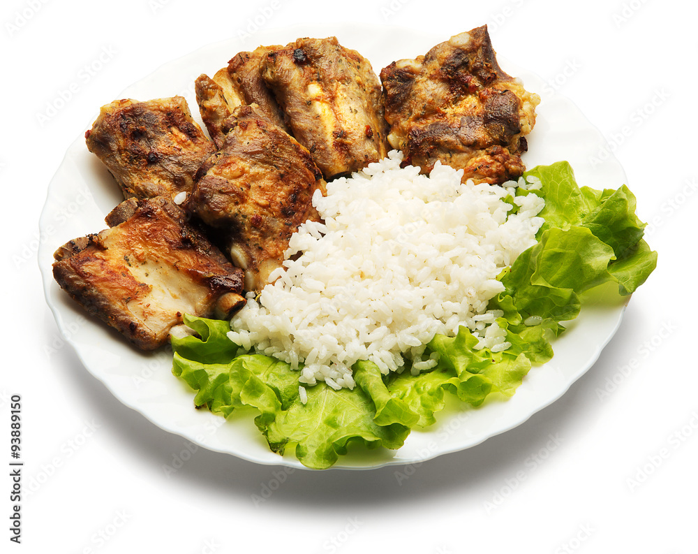 Pork ribs and rice decorated with salad over white background Stock