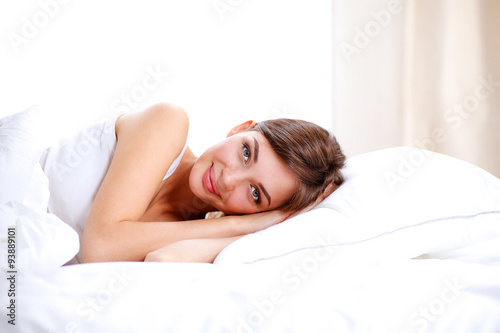 Beautiful girl lying in bedroom at early morning 