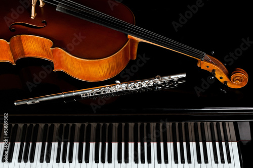 Musical instruments lying on the piano in dark colors