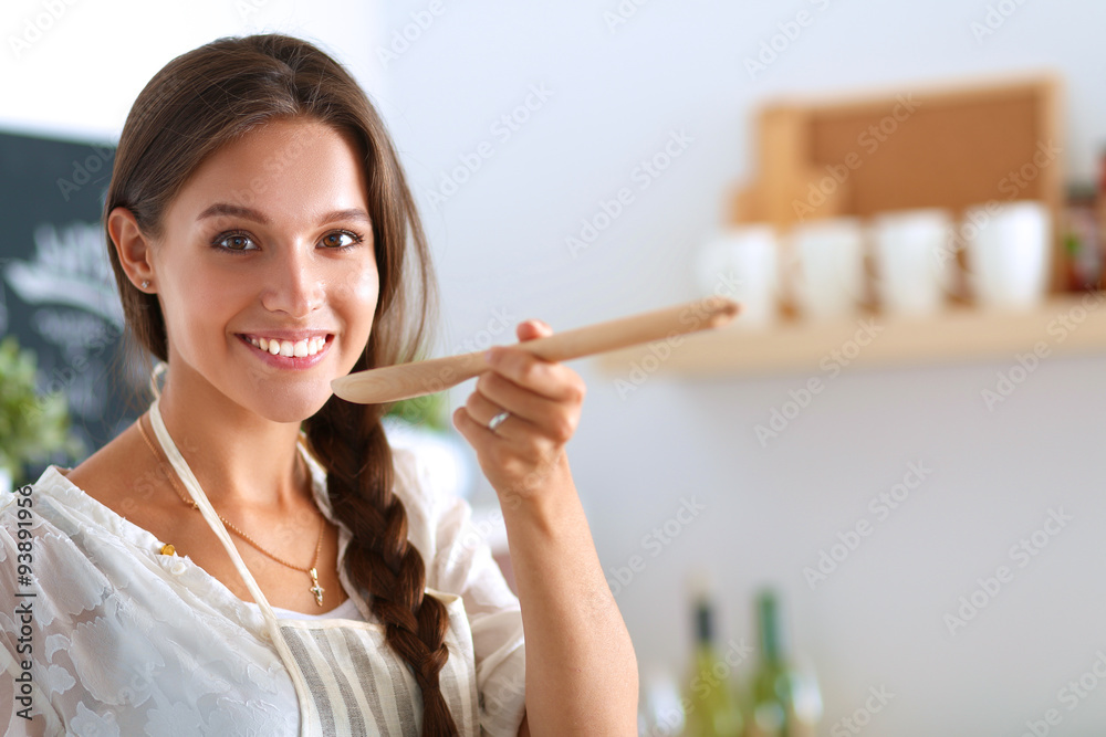 Cooking woman in kitchen with wooden spoon Cooking woman in kitchen with wooden spoon