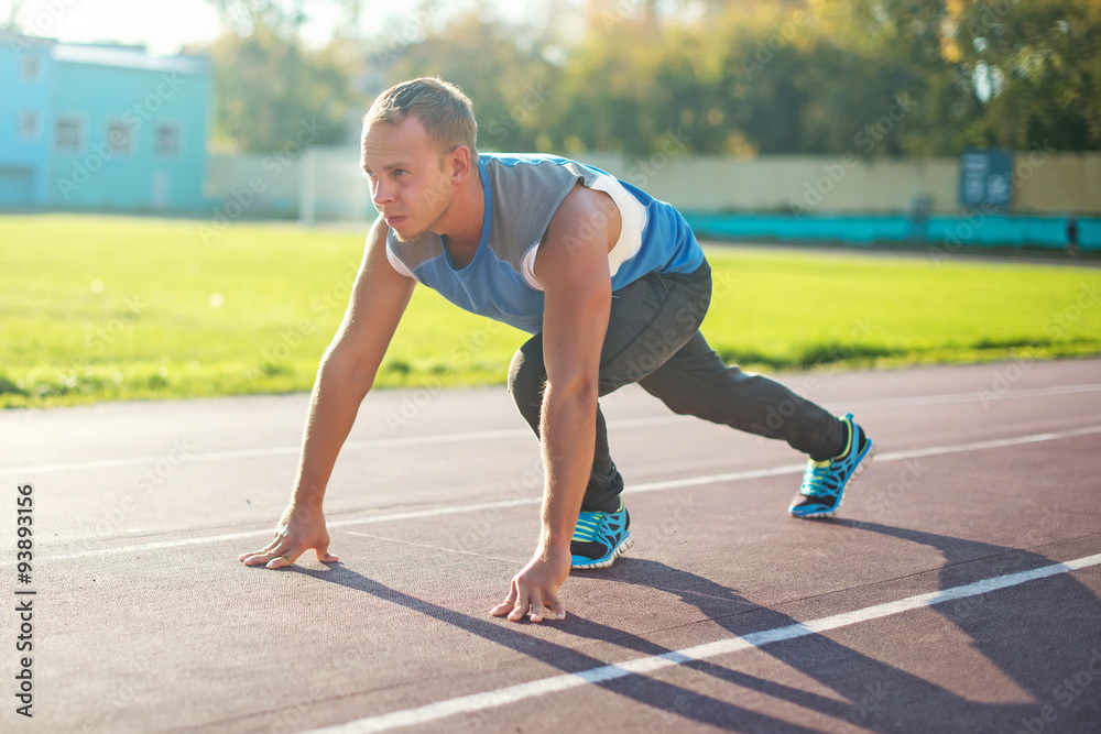 Athletic man standing in posture ready to run on a treadmill Athletic man standing in posture ready to run on a treadmill