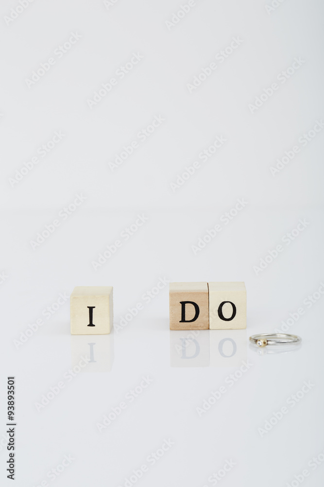 Letter tiles spelling 'I Do' next to wedding ring Letter tiles spelling 'I Do' next to wedding ring