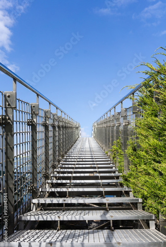 Stairway to heaven - steel staircase going up to a blue sky with