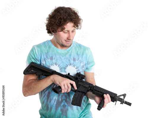 Adult man holding machine gun in hands and looking at weapon, isolated on white background