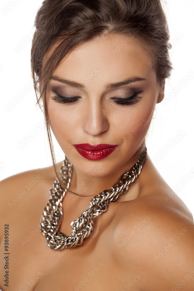 a young beautiful woman posing with a big necklace
