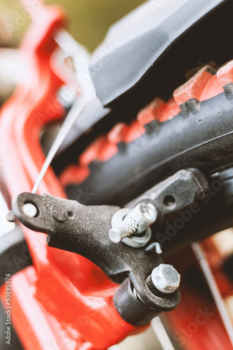 Close up of front brake of red and black mountain bicycle. 