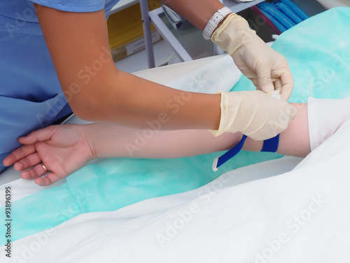Doctor drawing blood from female patient's arm for examination