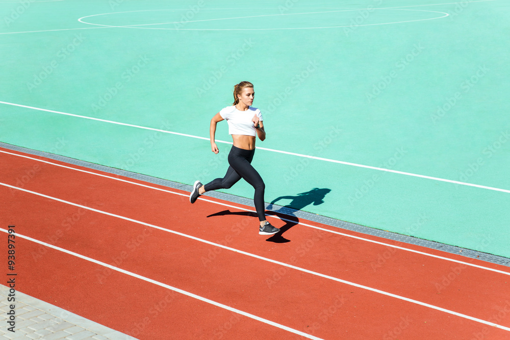 Female jogger running at stadium