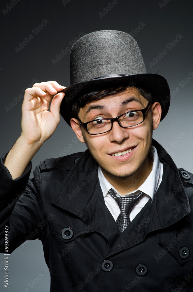 Young man in black coat and hat against gray Young man in black coat and hat against gray