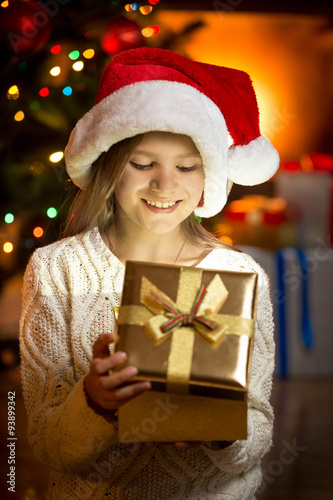 excited girl looking inside of glittering present box