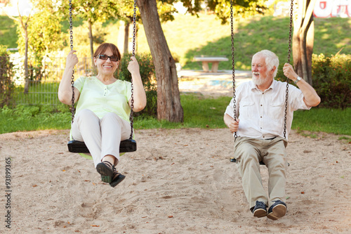 Senior couple swinging in the park