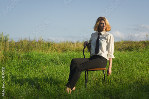 Beauty woman sitting in the armchair at the field