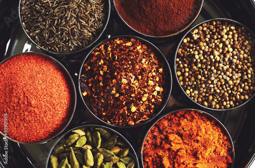 Fototapeta Naklejka Na Ścianę i Meble -  Rack with traditional indian spices for cooking - cardamom, turmeric, cumin, coriander seeds, cinnamon and chili