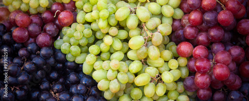 Various kinds of fresh grapes at market stall
