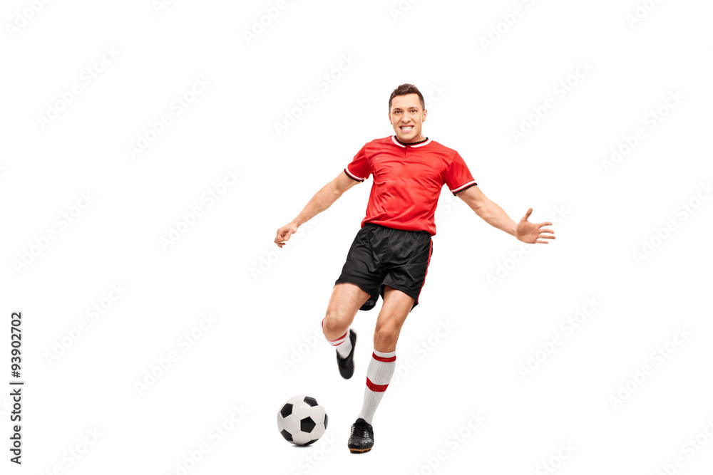 Determined young football player shooting a ball