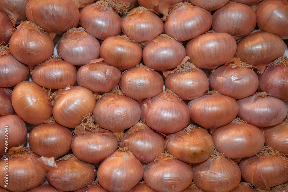 Obraz premium Fine stacked onions at market stall