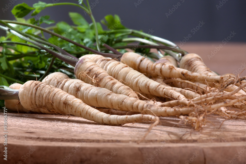 fresh parsley with roots on wooden cutting board fresh parsley with roots on wooden cutting board
