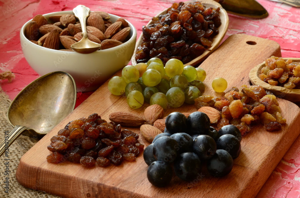 Various raisins, vine berries and almonds on chopping board Various raisins, vine berries and almonds on chopping board
