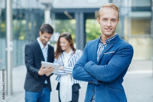 Young businessman posing in front of a small group of business p