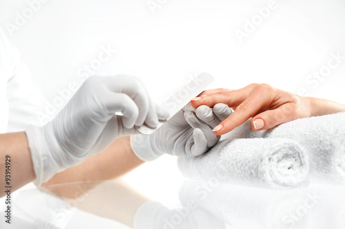 Piłowanie paznokci, manicure. Zabieg pielęgnacyjny dłoni i paznokci, kobieta u kosmetyczki na zabiegu manicure.