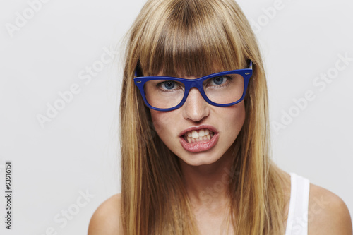 Fotografi Clever and angry young woman snarling at camera