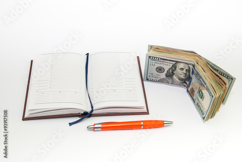 pen, empty open notebook, dollar bills on white background