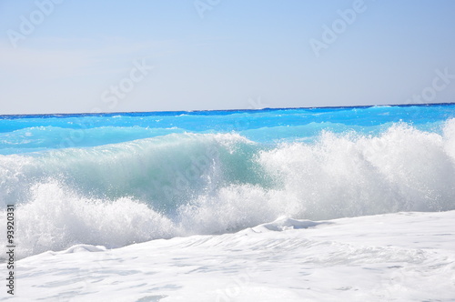 Waves on a sandy beach and a fairytale blue water